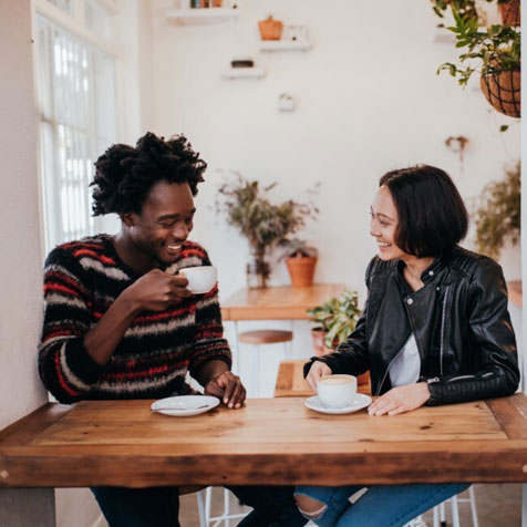 A couple sitting at a table drinking coffee